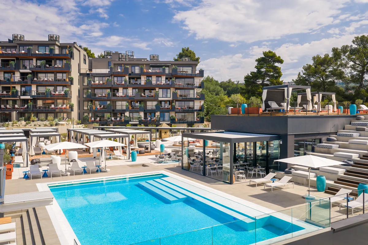 Vanjski bazen sa sunčalištem i rezidencijalne zgrade Aminess Younique Vollo Hotel Residences