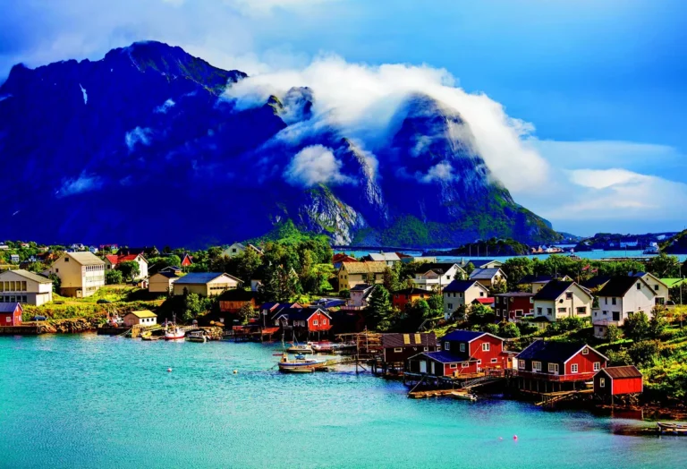 Ribarsko selo sa crvenim kućama uz fjord i planine na sjeveru Norveške