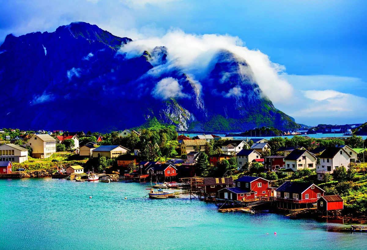Ribarsko selo sa crvenim kućama uz fjord i planine na sjeveru Norveške