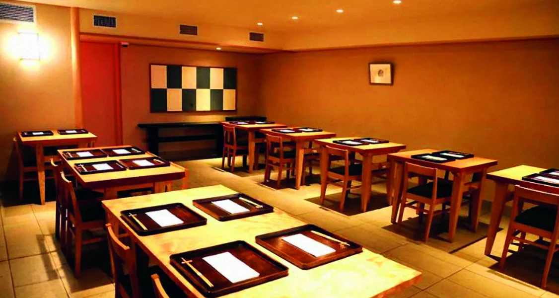 Blagovaonica japanskog restorana Kajitsu sa stolovima i drvenim pladnjevima